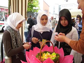 三名土耳其少女高兴地接过漂亮的纸莲花