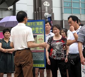 一零一大楼景点前的真相展板围着层层的中国游客争相了解事实、听学员讲真相