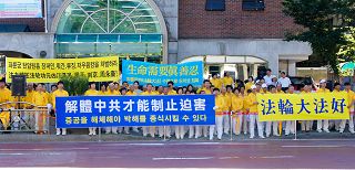 七月二十日，韩国首尔法轮功学员与市民团体在中共驻韩使馆前举行集会，抗议中共迫害法轮功十二年。