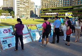七月二十日下午，各国游客观看韩国法轮功学员在首尔广场展出的真相展板。